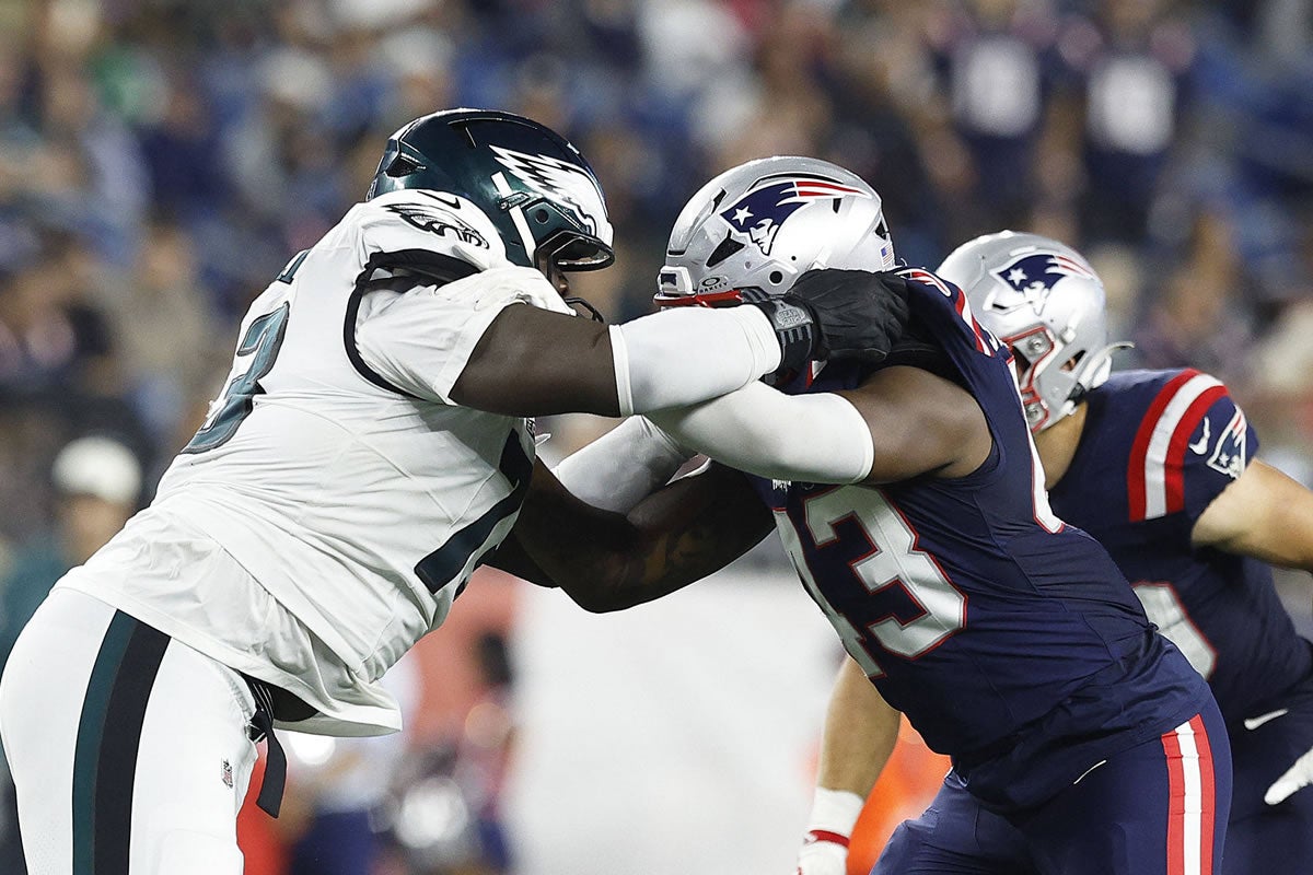 Cameron Williams (73, Philadelphia Eagles) und Bradyn Swinson (43, New England Patriots) während eines Zweikampfs in einem NFL-Vorbereitungsspiel im Gillette Stadium in Foxborough, Massachusetts.