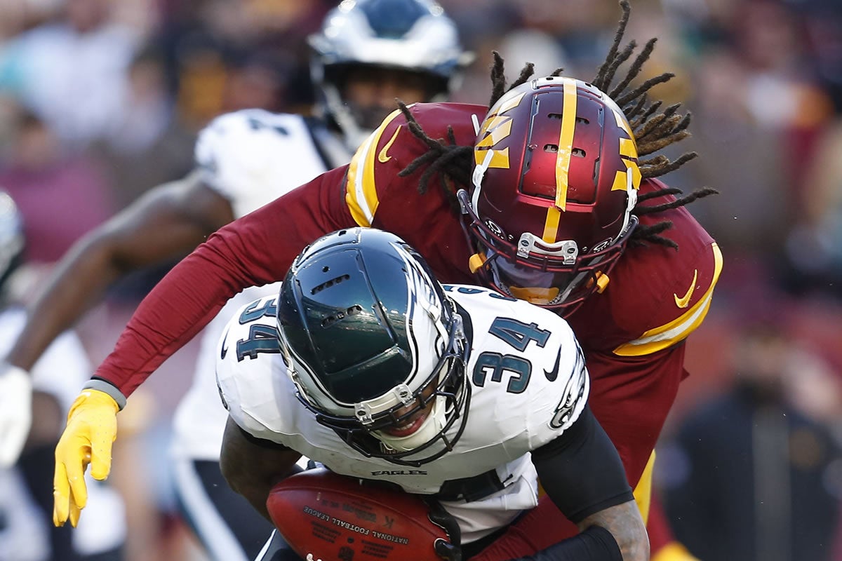 ANDOVER, MD - DECEMBER 22: Washington Commanders linebacker Mykal Walker 32 tackles Philadelphia Eagles cornerback Isaiah Rodgers 34 during the Philadelphia Eagles game versus the Washington Commanders at Northwest Stadium on December 22, 2024, in Landover, MD.