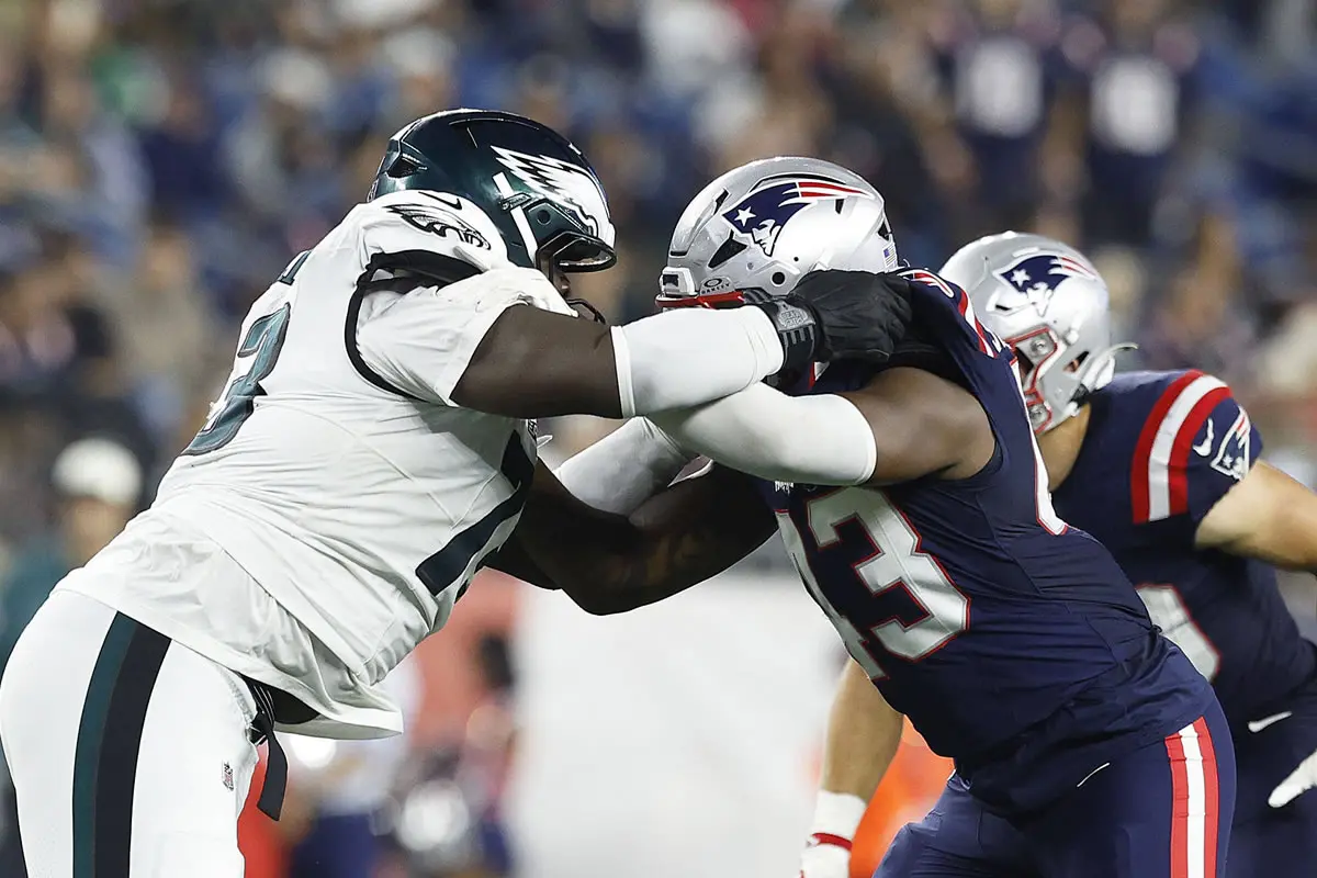 Cameron Williams (73, Philadelphia Eagles) und Bradyn Swinson (43, New England Patriots) während eines Zweikampfs in einem NFL-Vorbereitungsspiel im Gillette Stadium in Foxborough, Massachusetts.