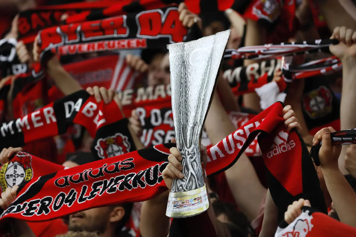 Eine Hand hält im Frankfurt Block eine Pappversion des Europa-League-Pokals in die Höhe.