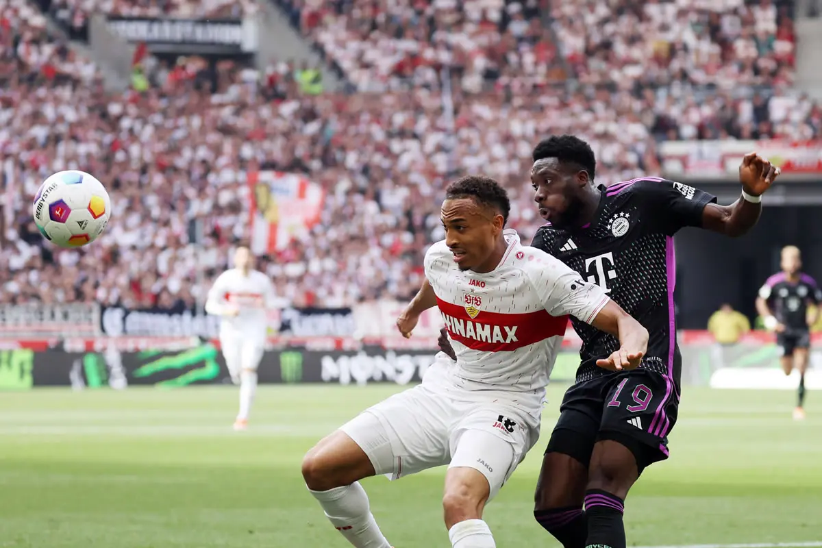 Zweikampf zwischen Jamie Leweling (VfB Stuttgart) und Alphonso Davies (FC Bayern München)