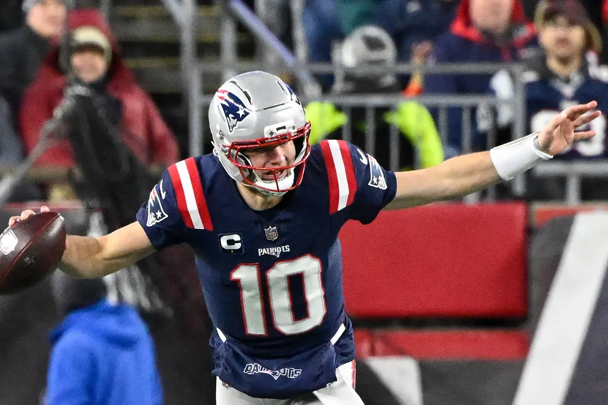 New England Patriots Quarterback Drake Maye 10 springt über Miami Dolphins Linebacker Quinton Bell.